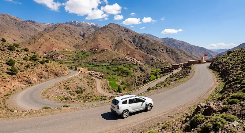 Driving a white rental SUV in the scenic Atlas Mountains near Marrakech